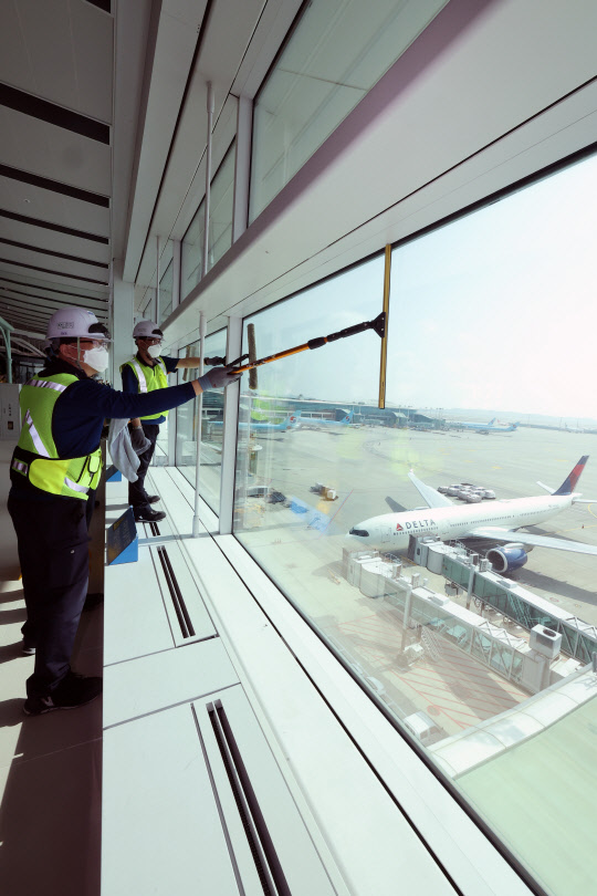 지난 15일 인천국제공항 전망대에서 작업자들이 유리창 등을 청소하고 있다. 인천국제공항공사 측은 코로나 엔데믹 이후 여객수요 회복에 대비해 공항 시설 전반에 대한 시설 점검 및 환경정비를 실시한다고 밝혔다. <연합뉴스>